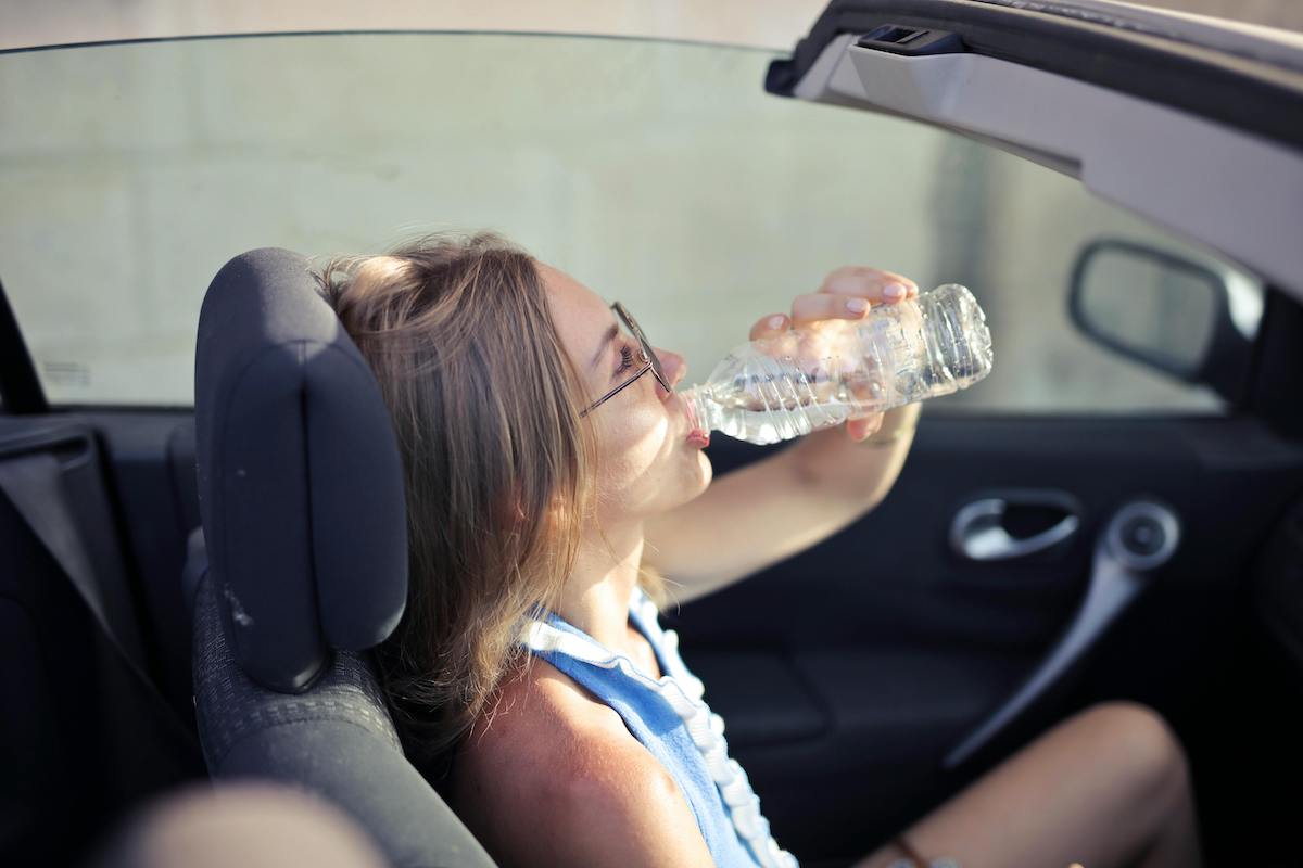 Girl Drinking water in a hot car