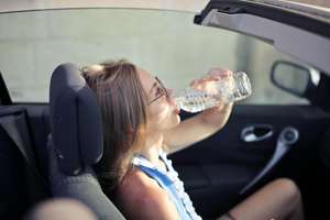 Girl Drinking water in a hot car
