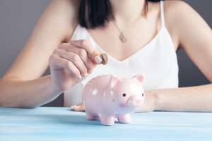 Lady adding money to piggy bank